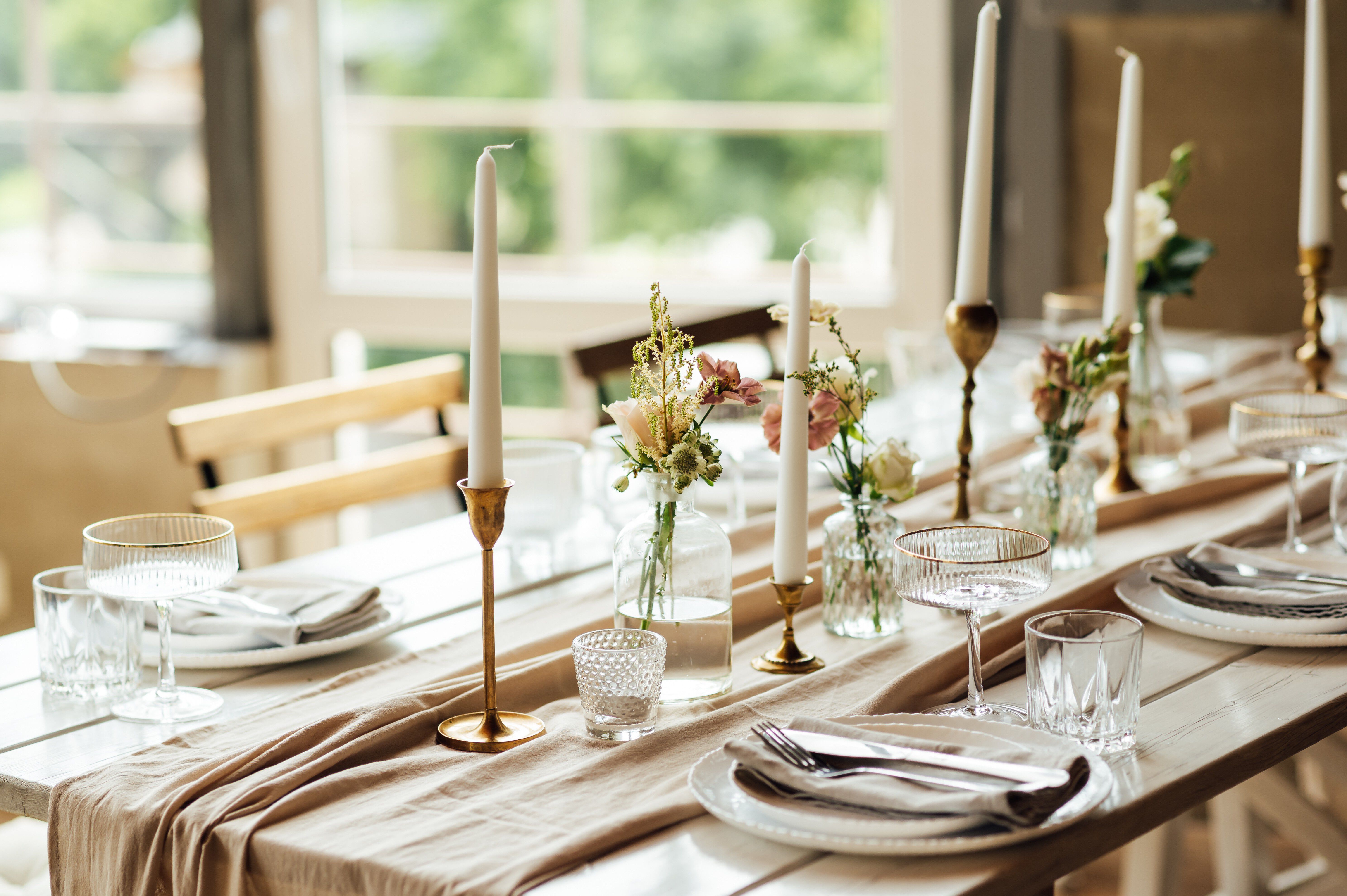 Casual, yet elegant table set with tapered candles and spring floral in a mix of vases