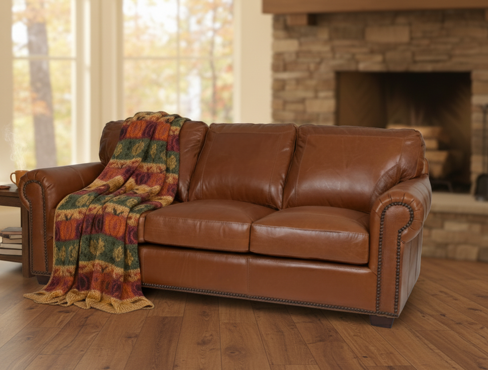 Leather sofa with thrown and fireplace in background