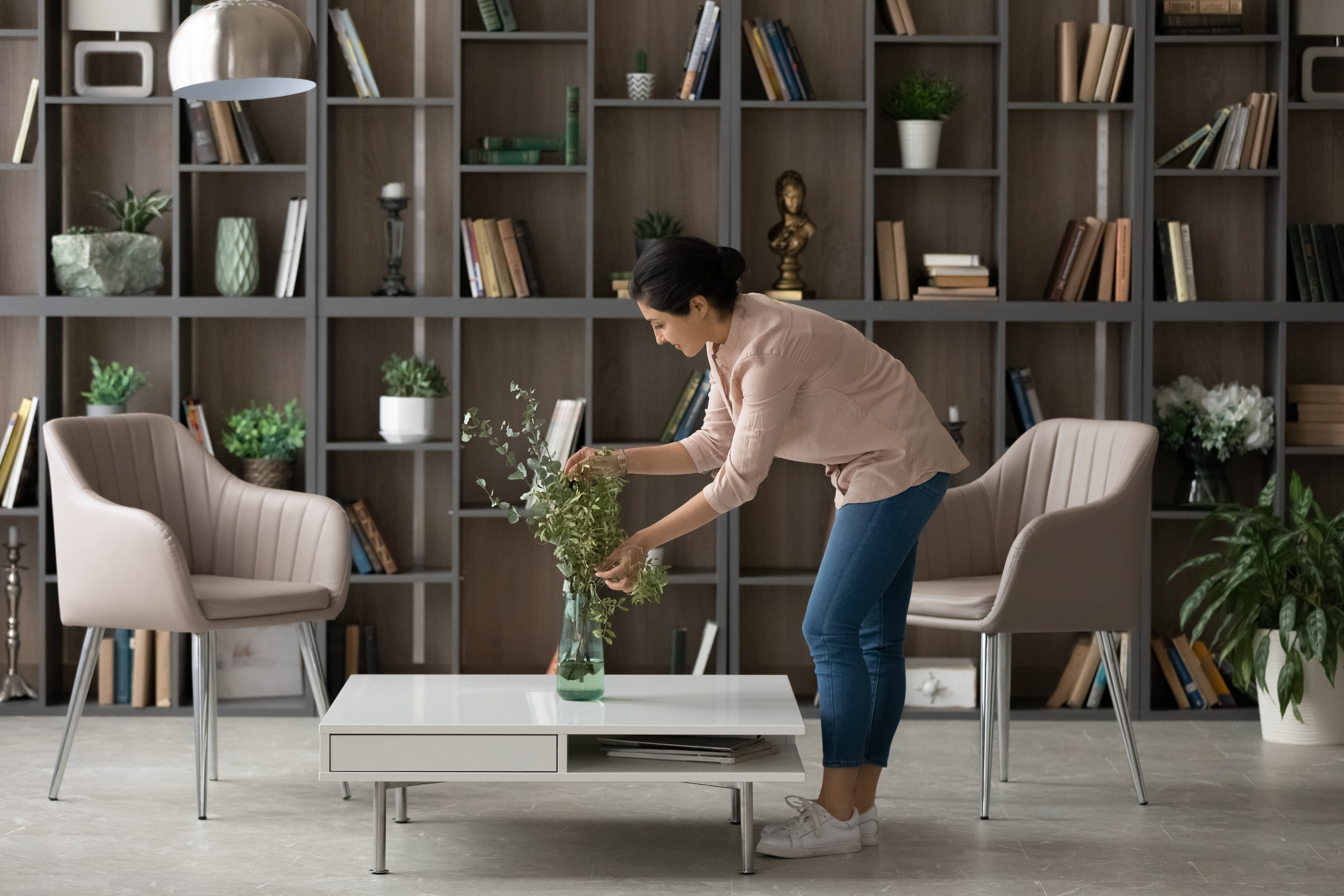 woman rearranging eucalyptus in her living room