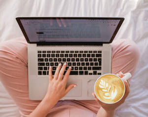 woman on computer holding coffee