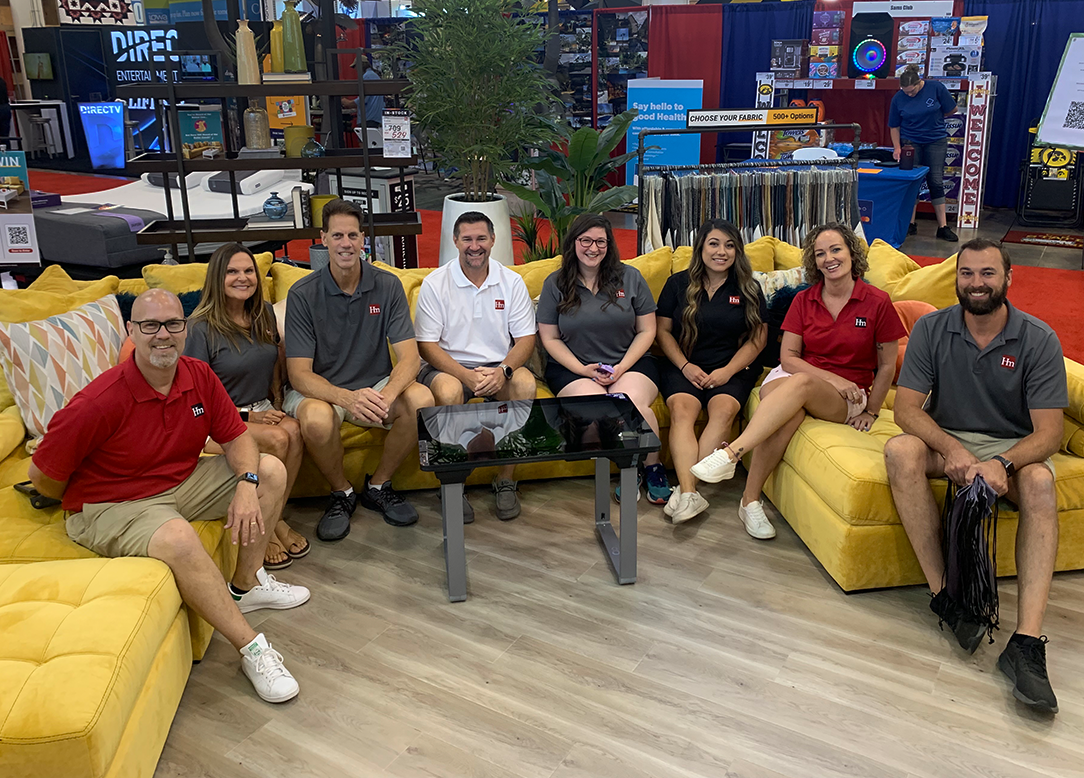 Employees sitting in the Hm Iowa State Fair booth
