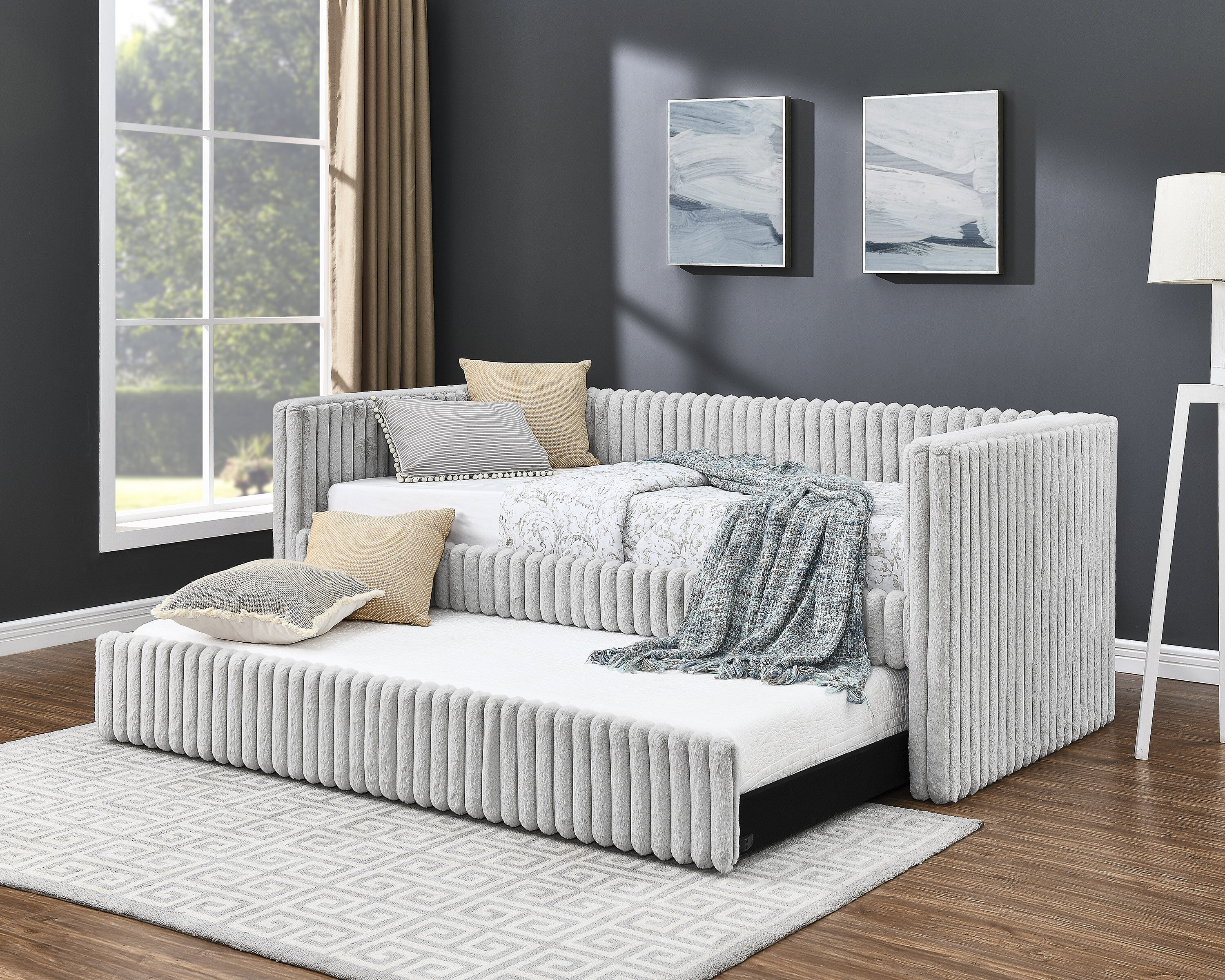 Gray, plush daybed with trundle in a spare bedroom and office space.