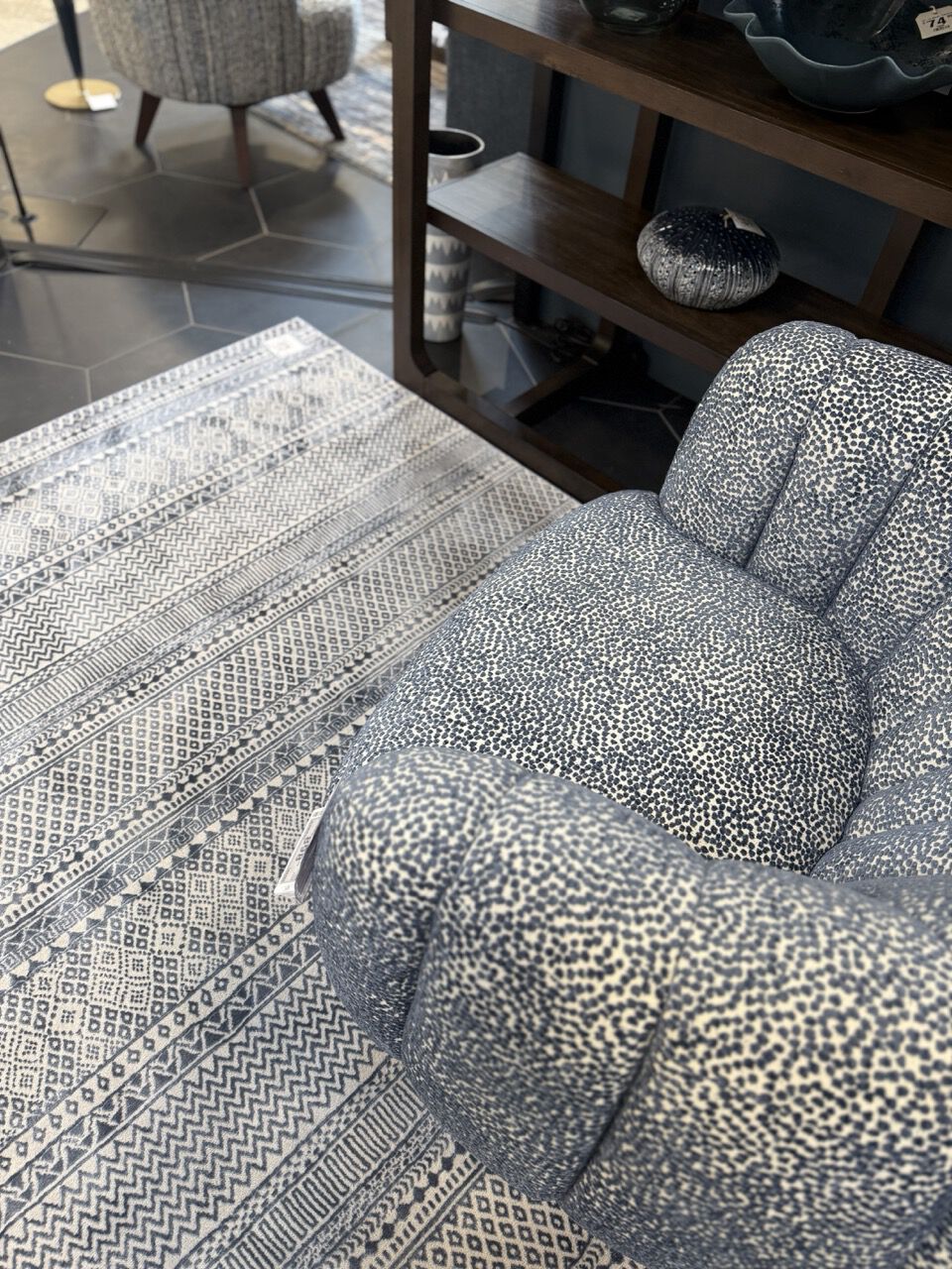 dotted blue tufted chair on top of a blue patterned rug