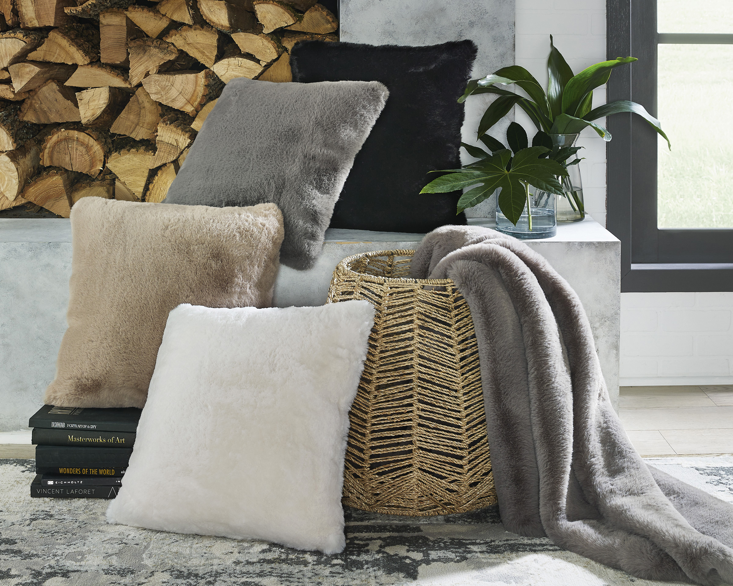 A large basket with throw and surrounding toss pillows