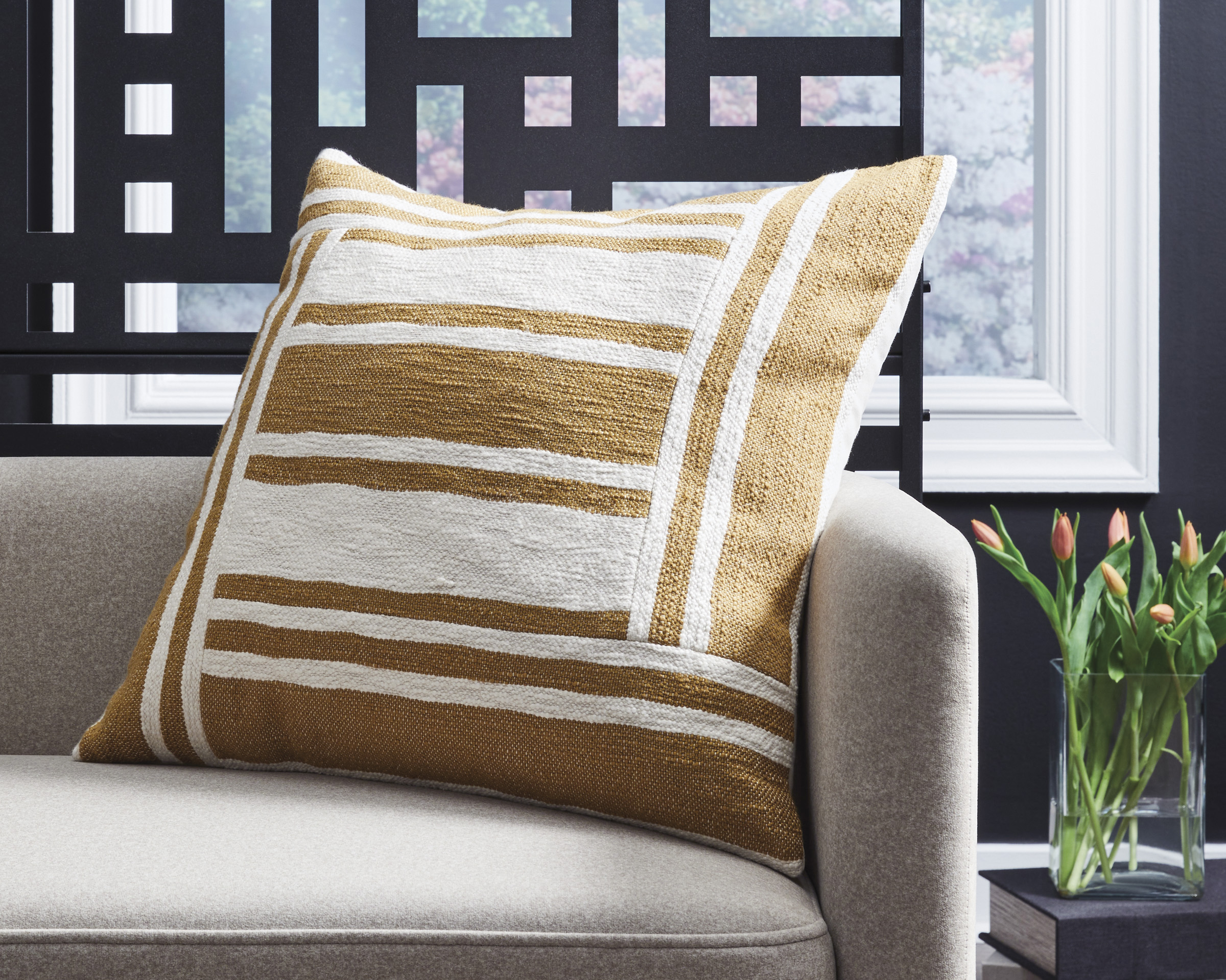 Yellow and natural throw pillow sittin on petitie sofa