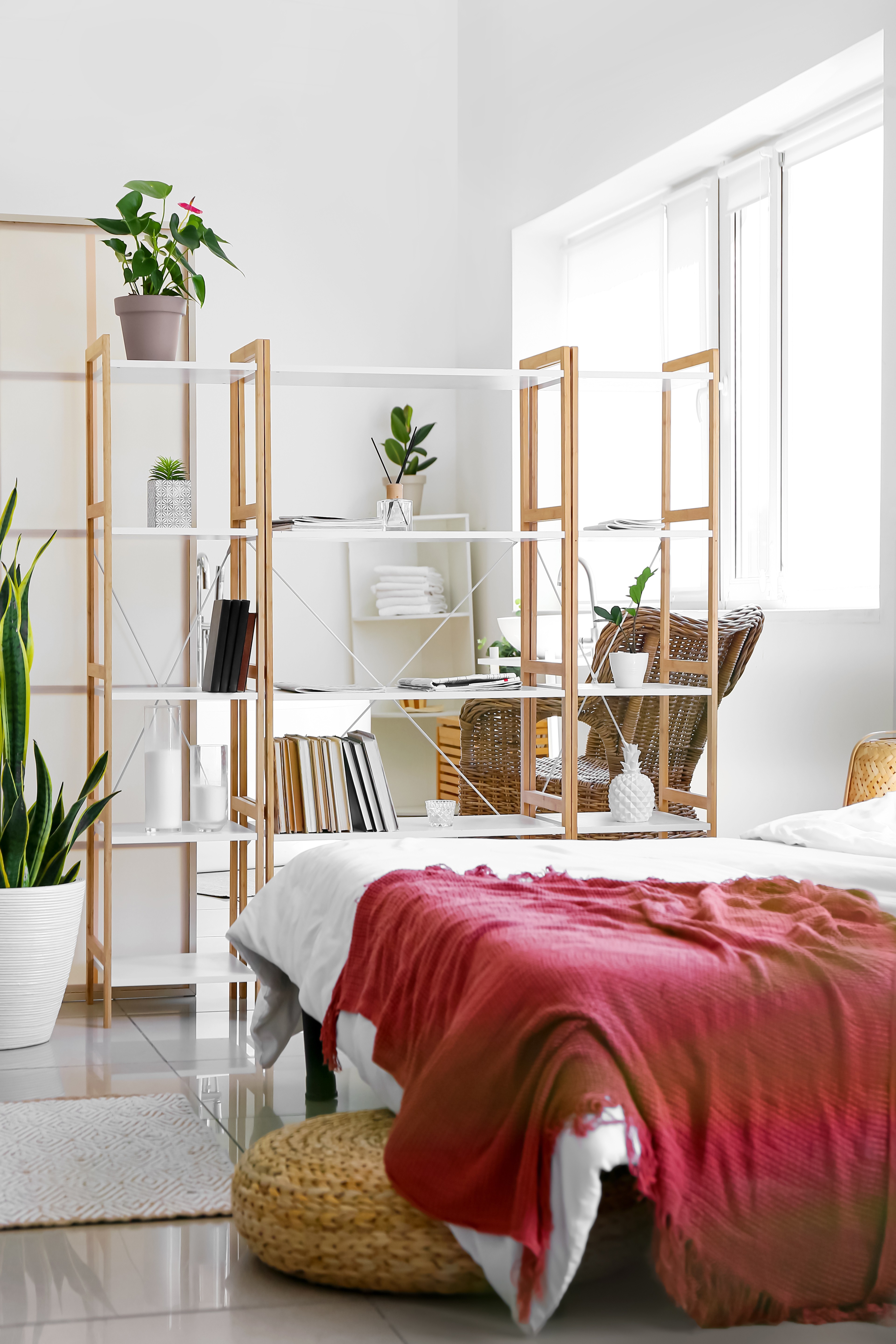 White bookshelves dividing bedroom from office space