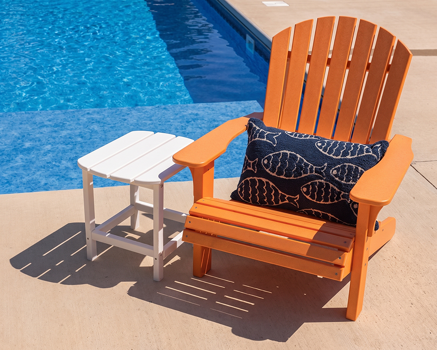 orange adirondack chair in front of pool