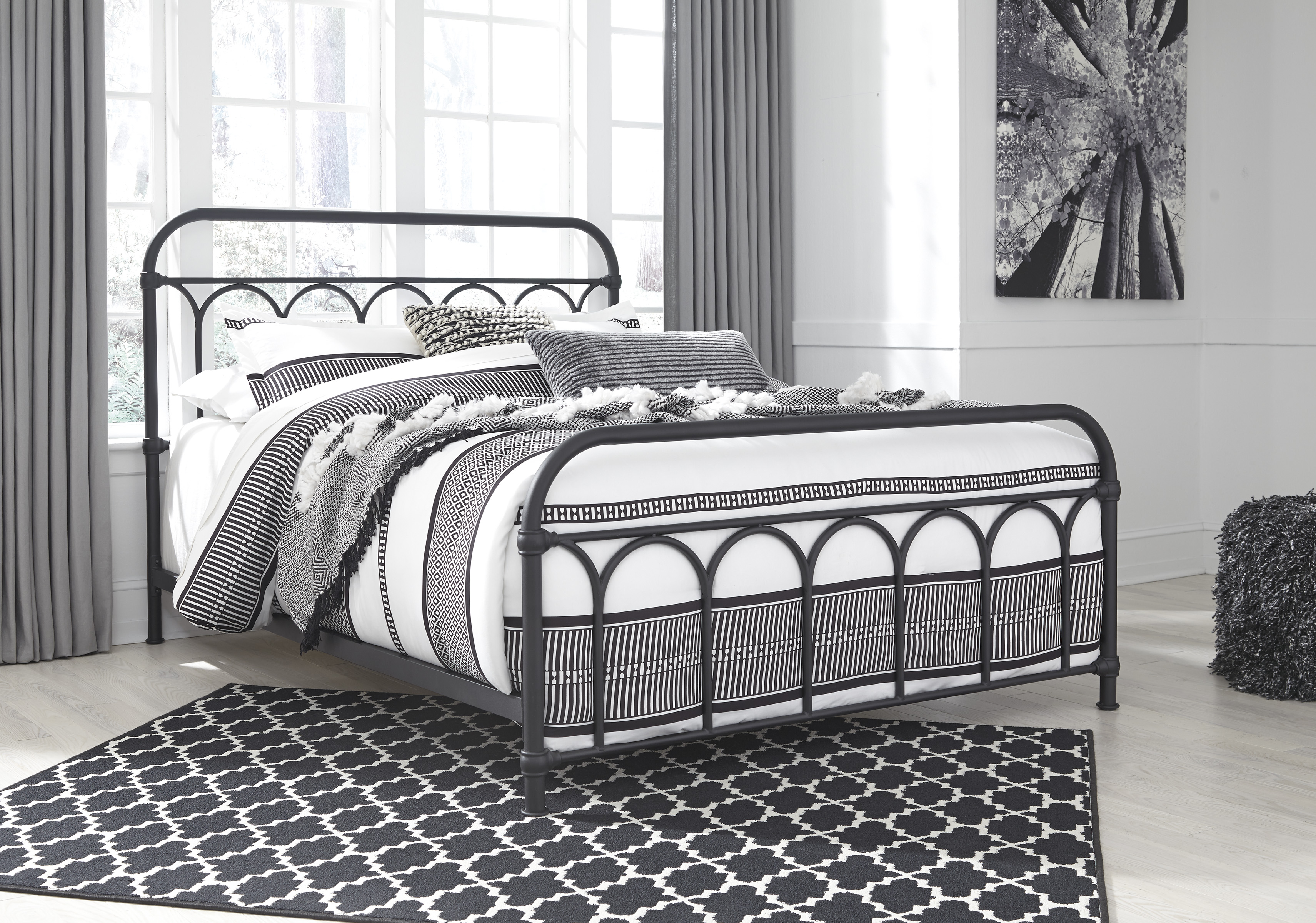 charming matte black metal bed with arched iron detail in the headboard and footboard