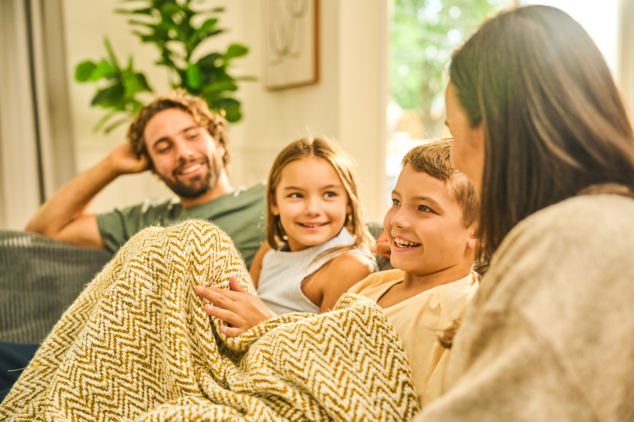 Family of four on the sofa enjoying time together