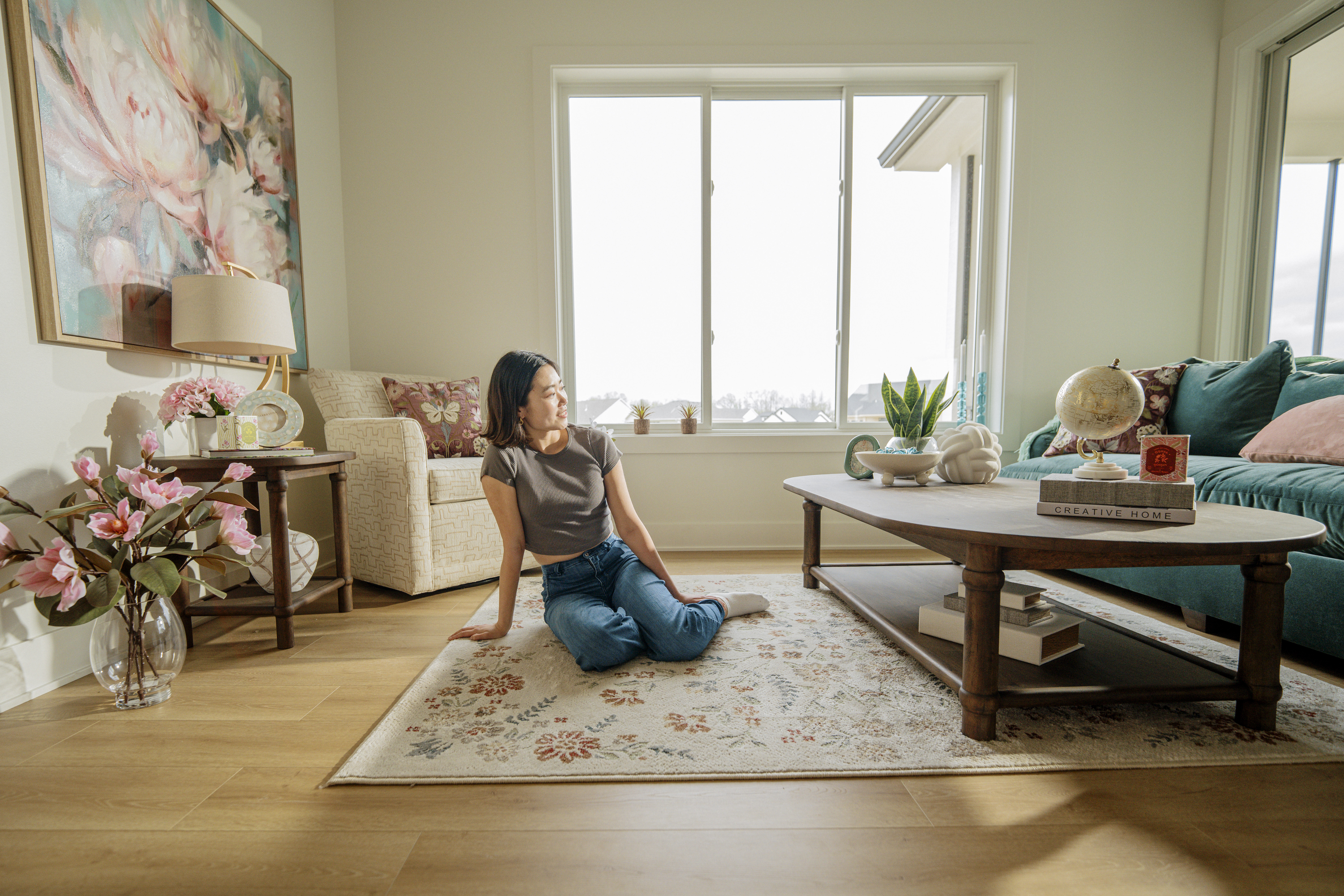 Woman enjoying her new coffee table decor while sitting on a rug