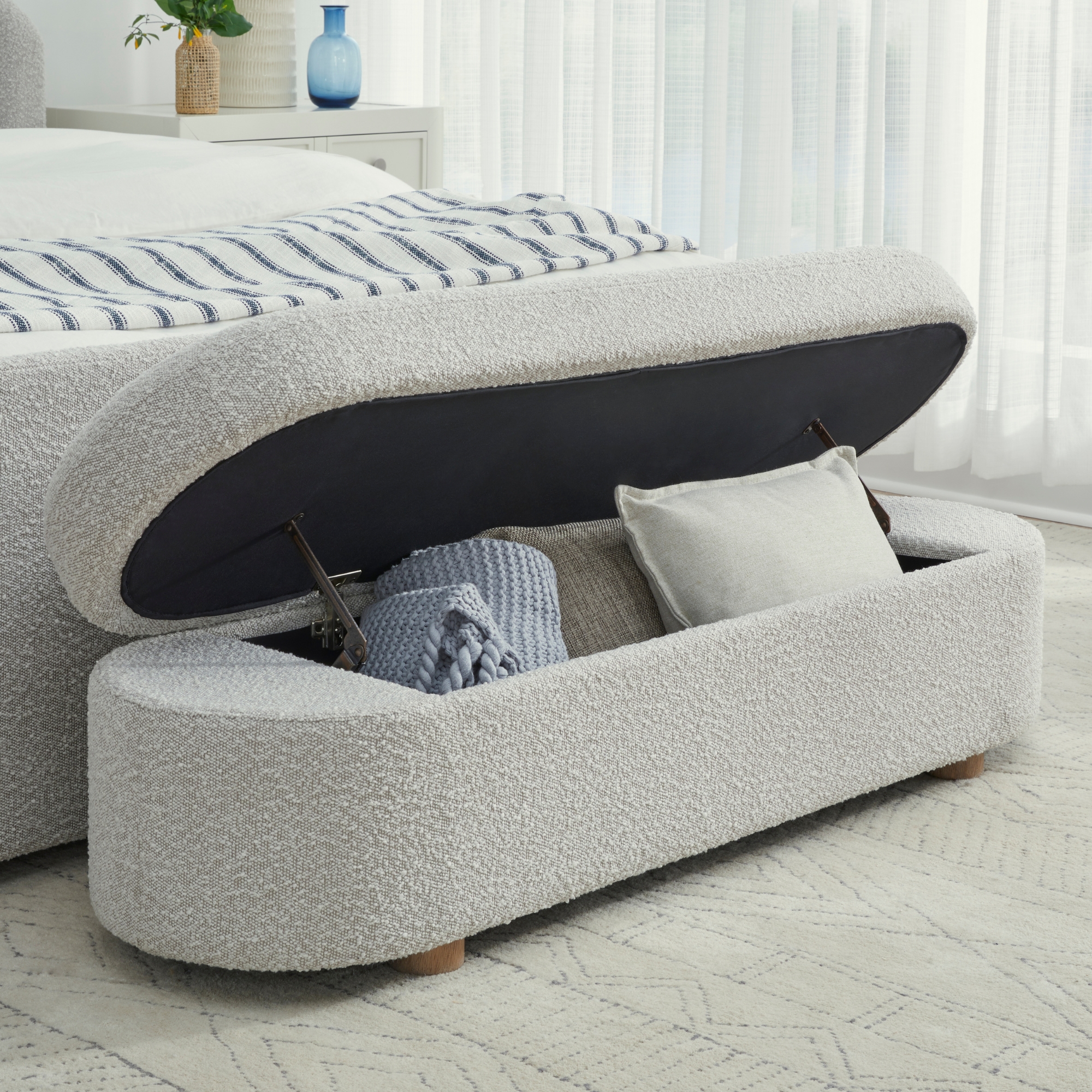 Light gray boucle oval shaped storage bench