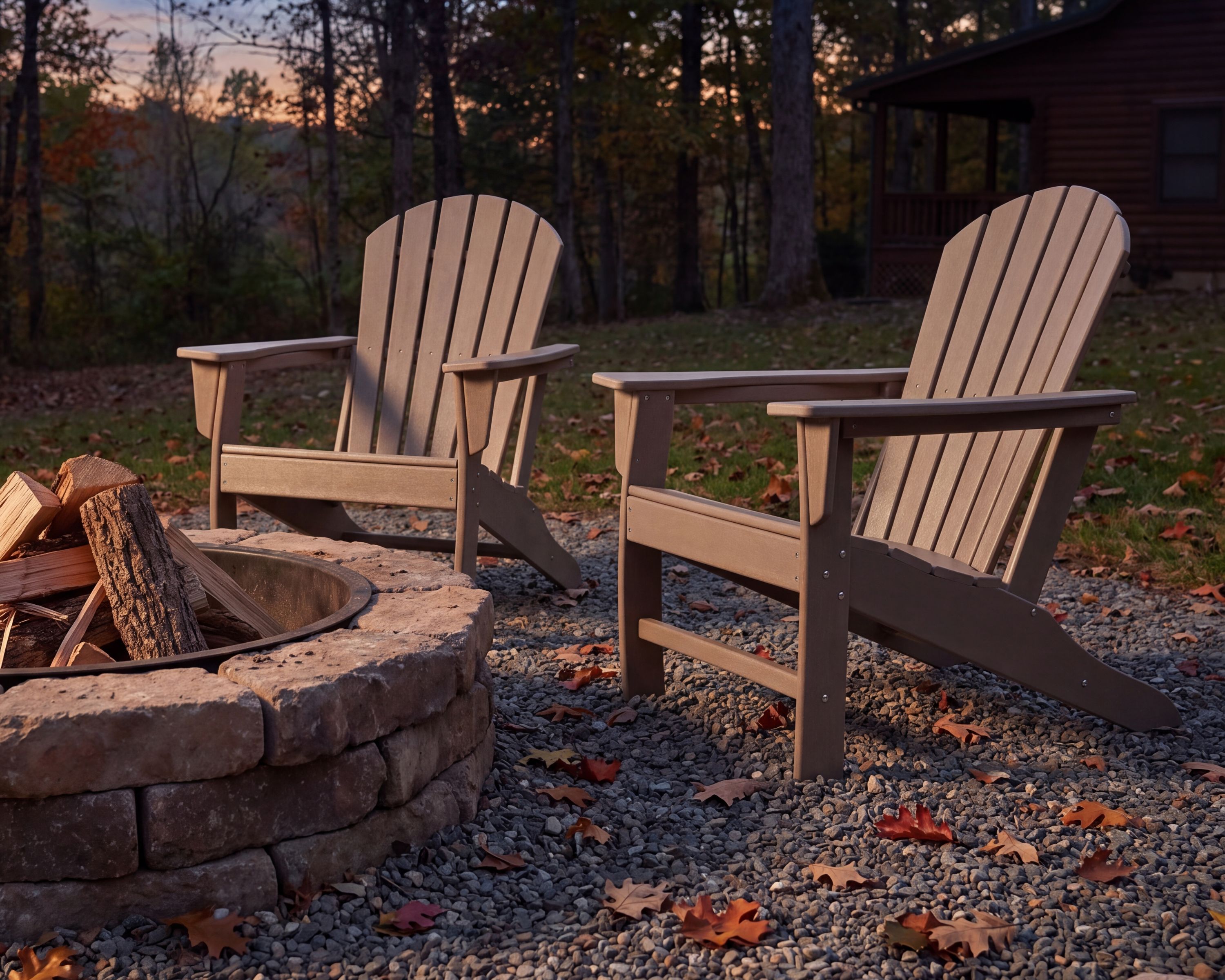 two tan adirondack chairs next to a firepit outside during an autumn evening