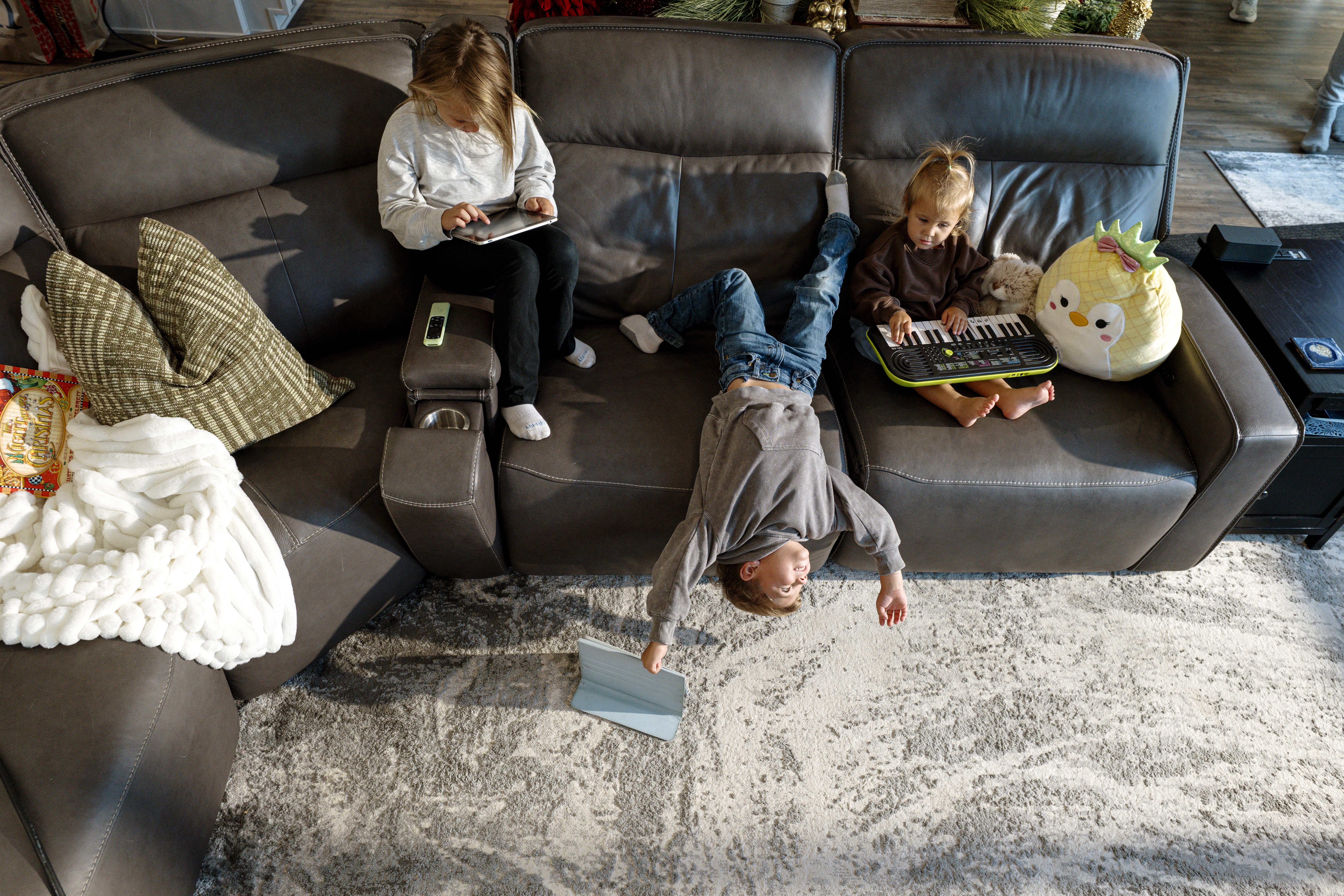 three kids on sofa with toys