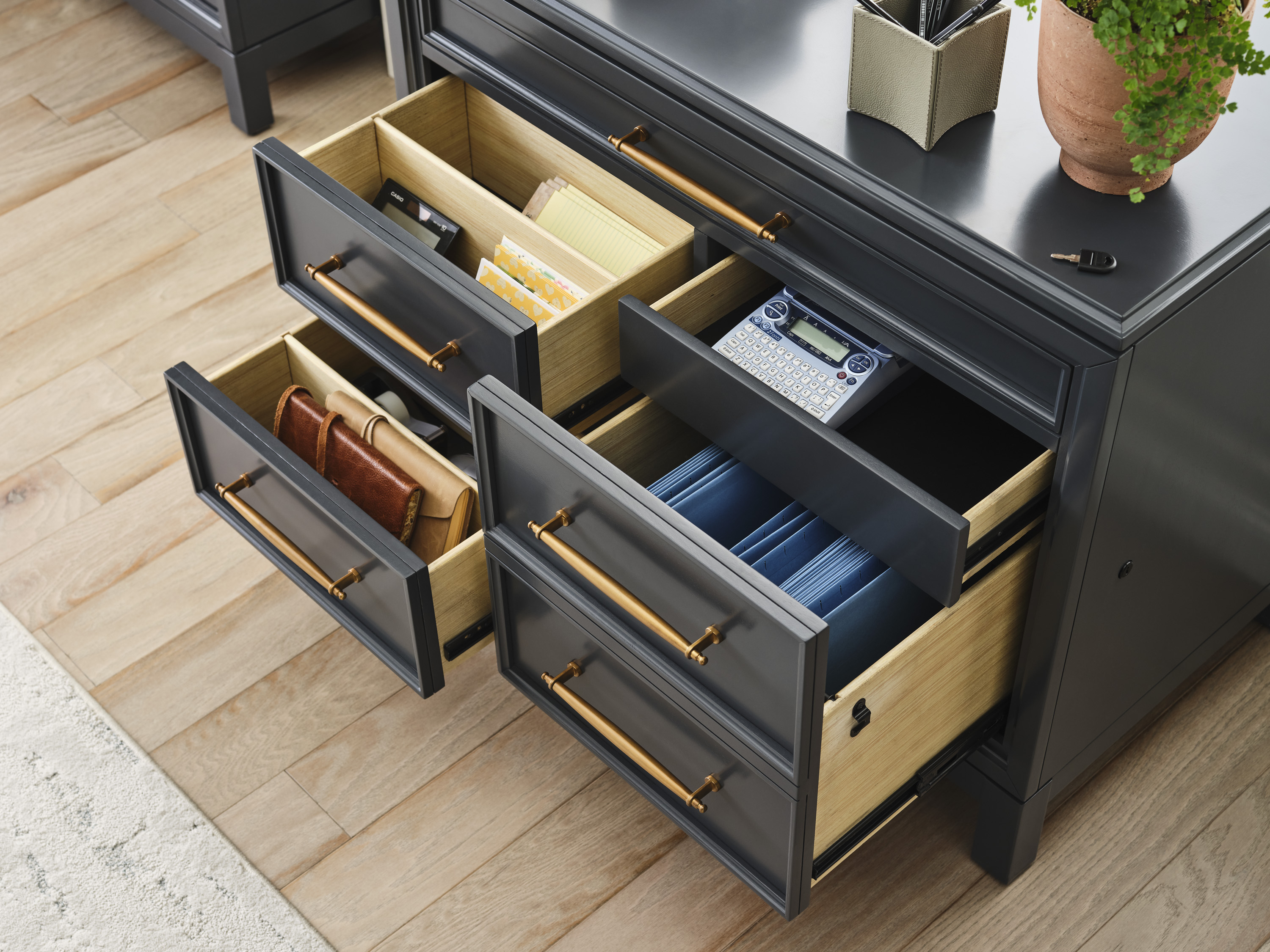 Dark blue file cabinet with golden/bronze hardware and multiple drawers