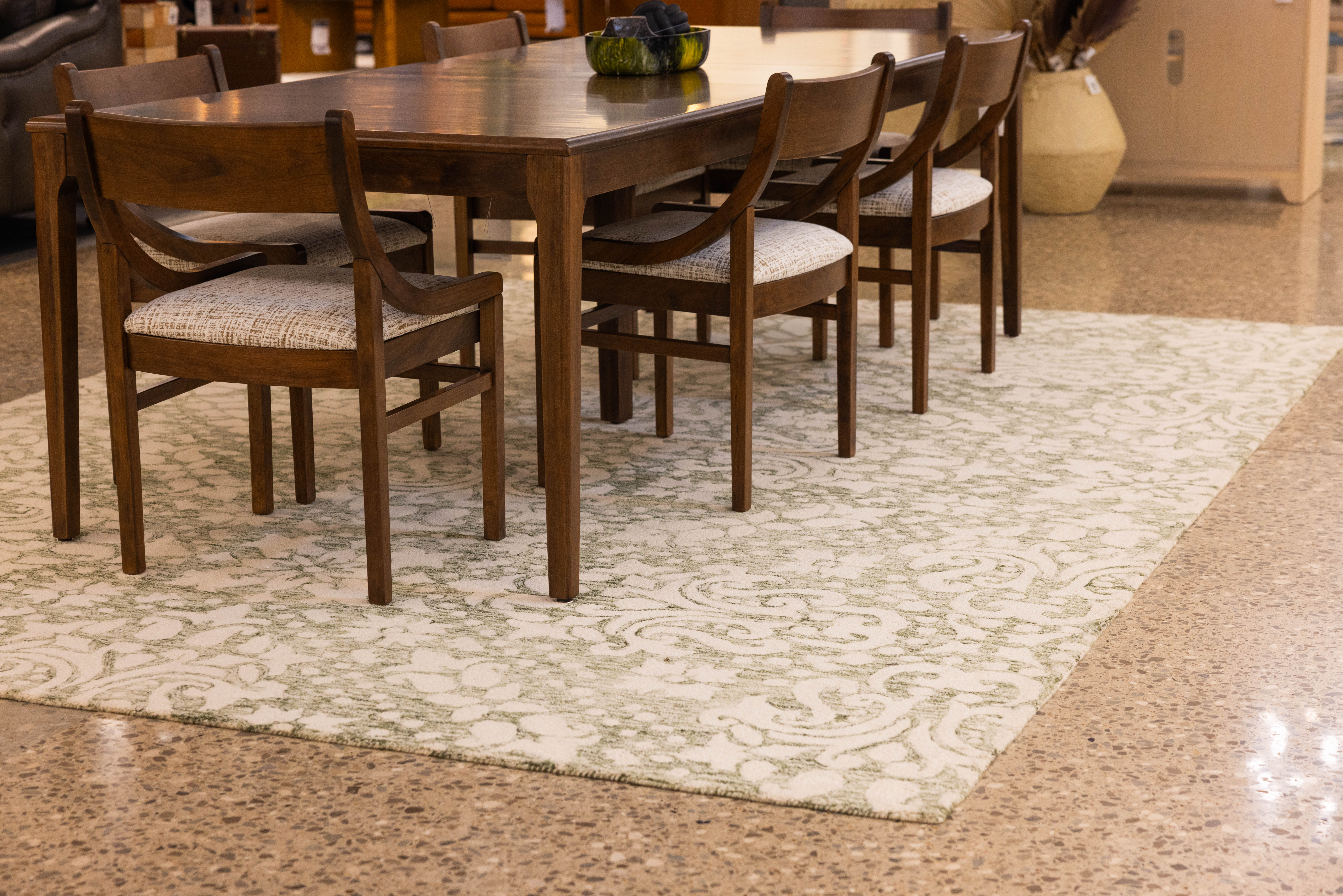 Dining room set on large green and ivory area rug