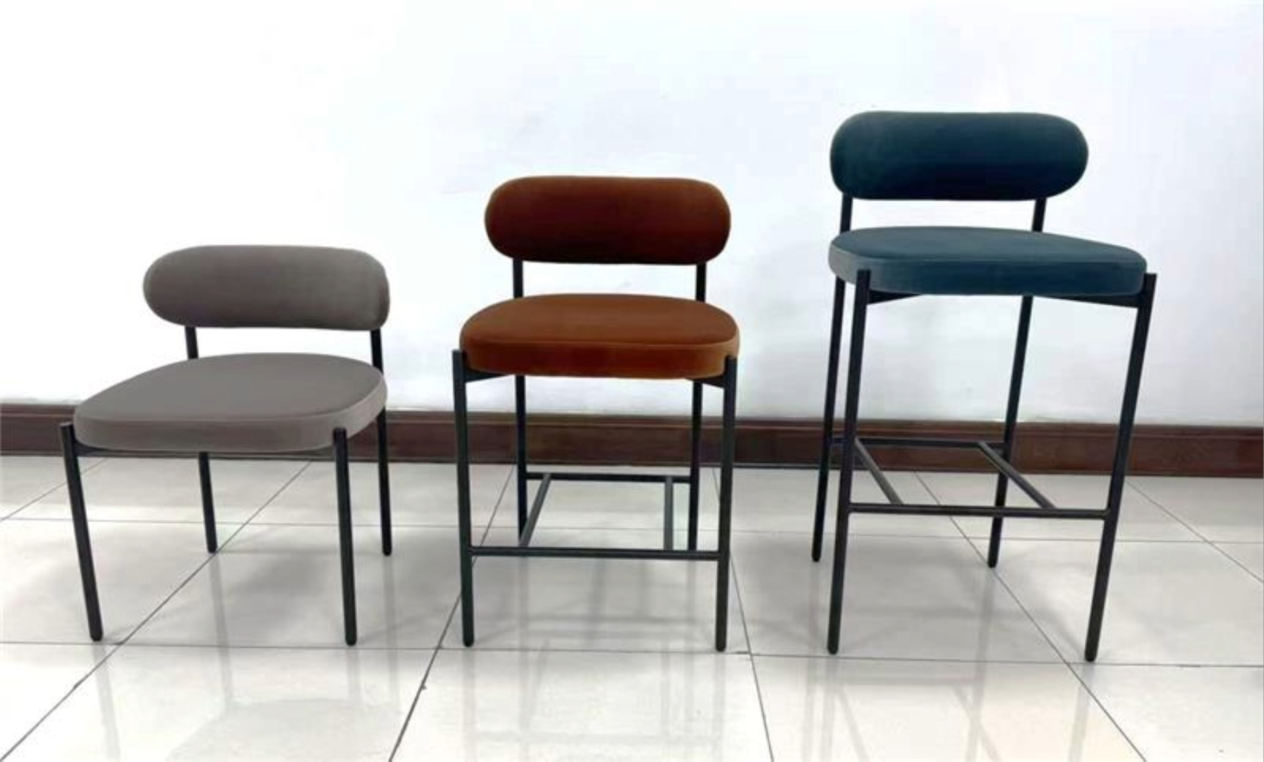 Three stools of varying heights in gray, brown and blue to show differences