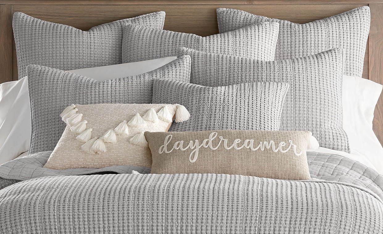 Cozy nutral grey bedding with lumbar pillow spelling daydream