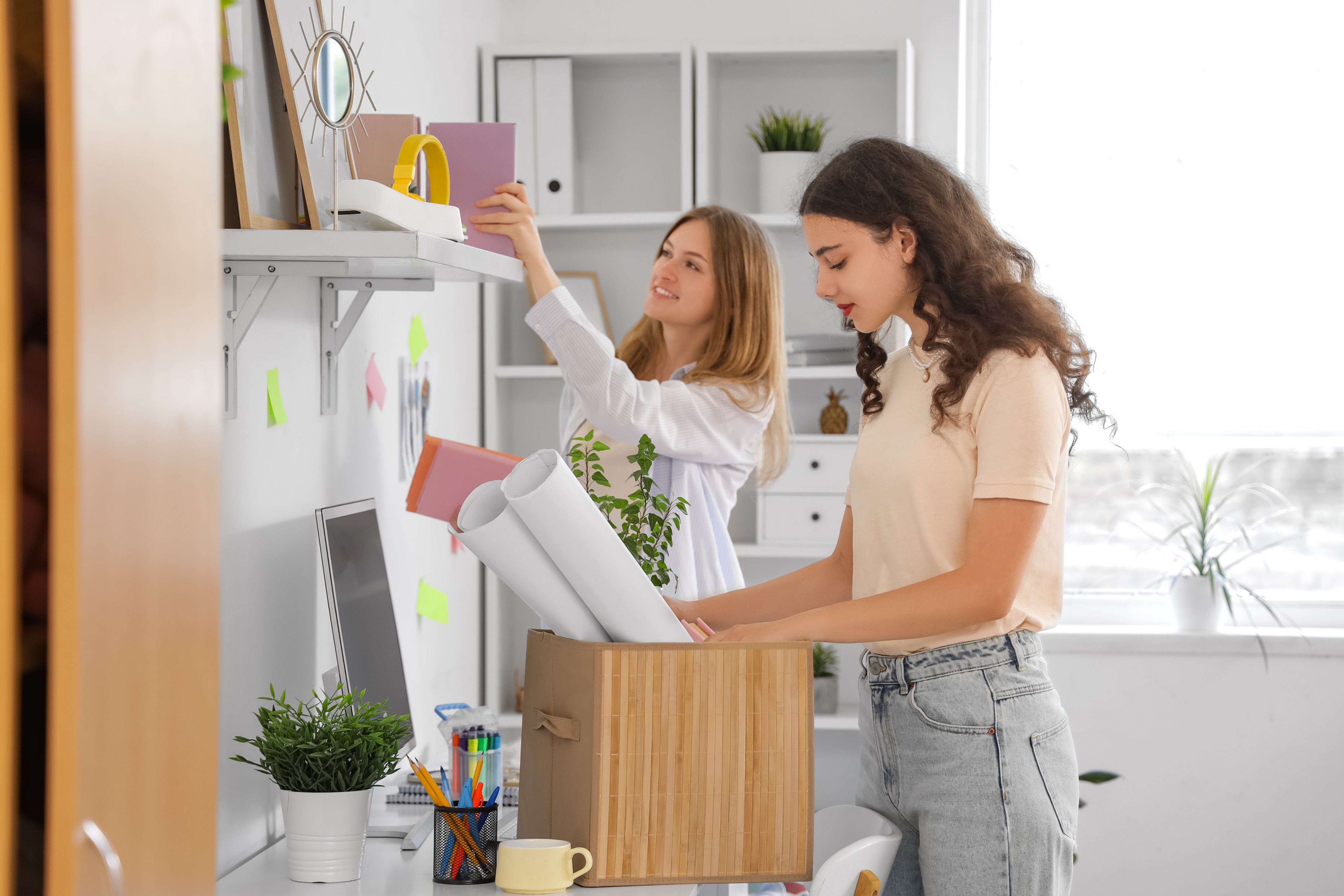 Two girls unpacking decor for their dorm room