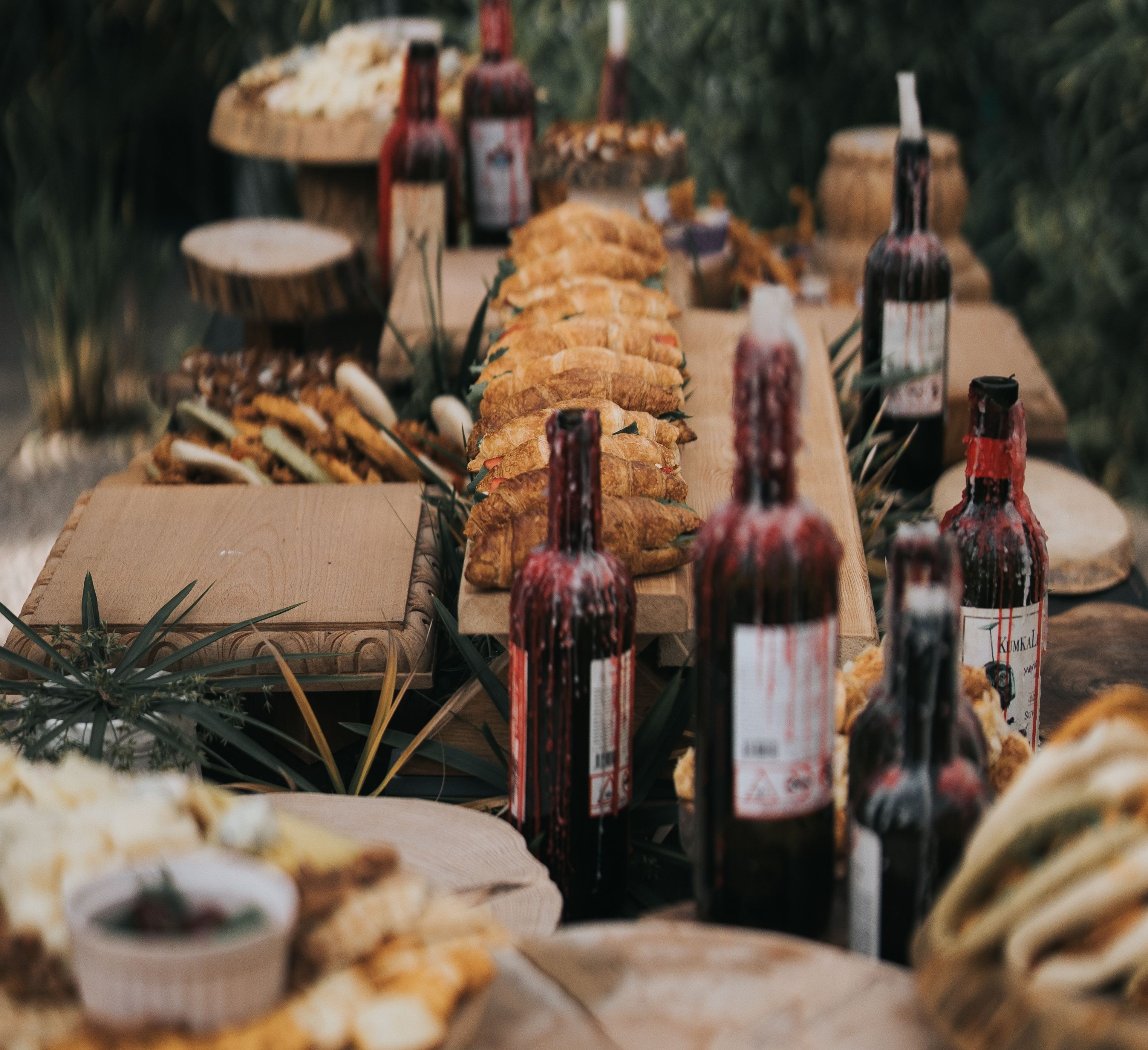 dark wine bottles with black taper candles and food on table