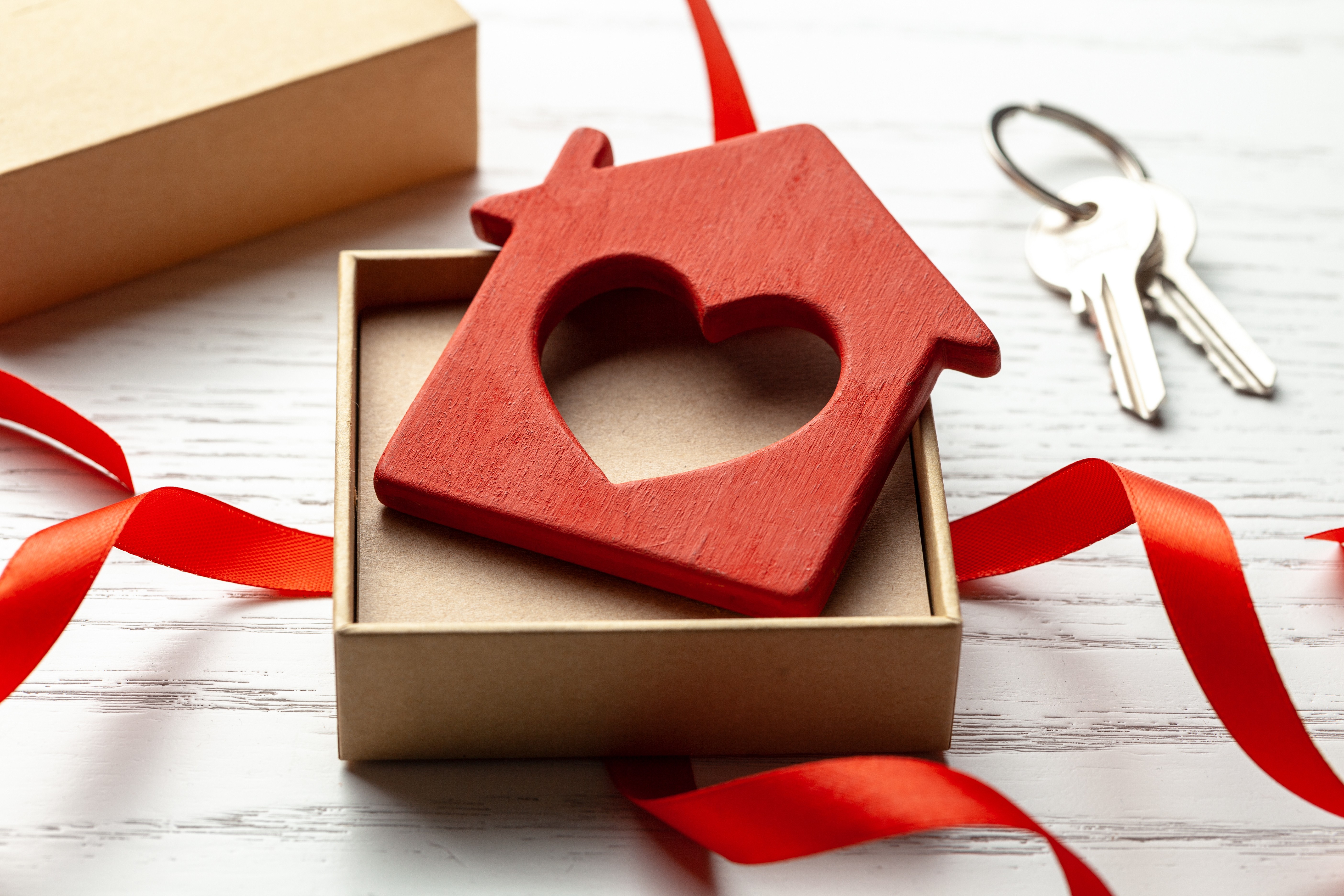 Wooden red house shaped keyring with a heart in the center