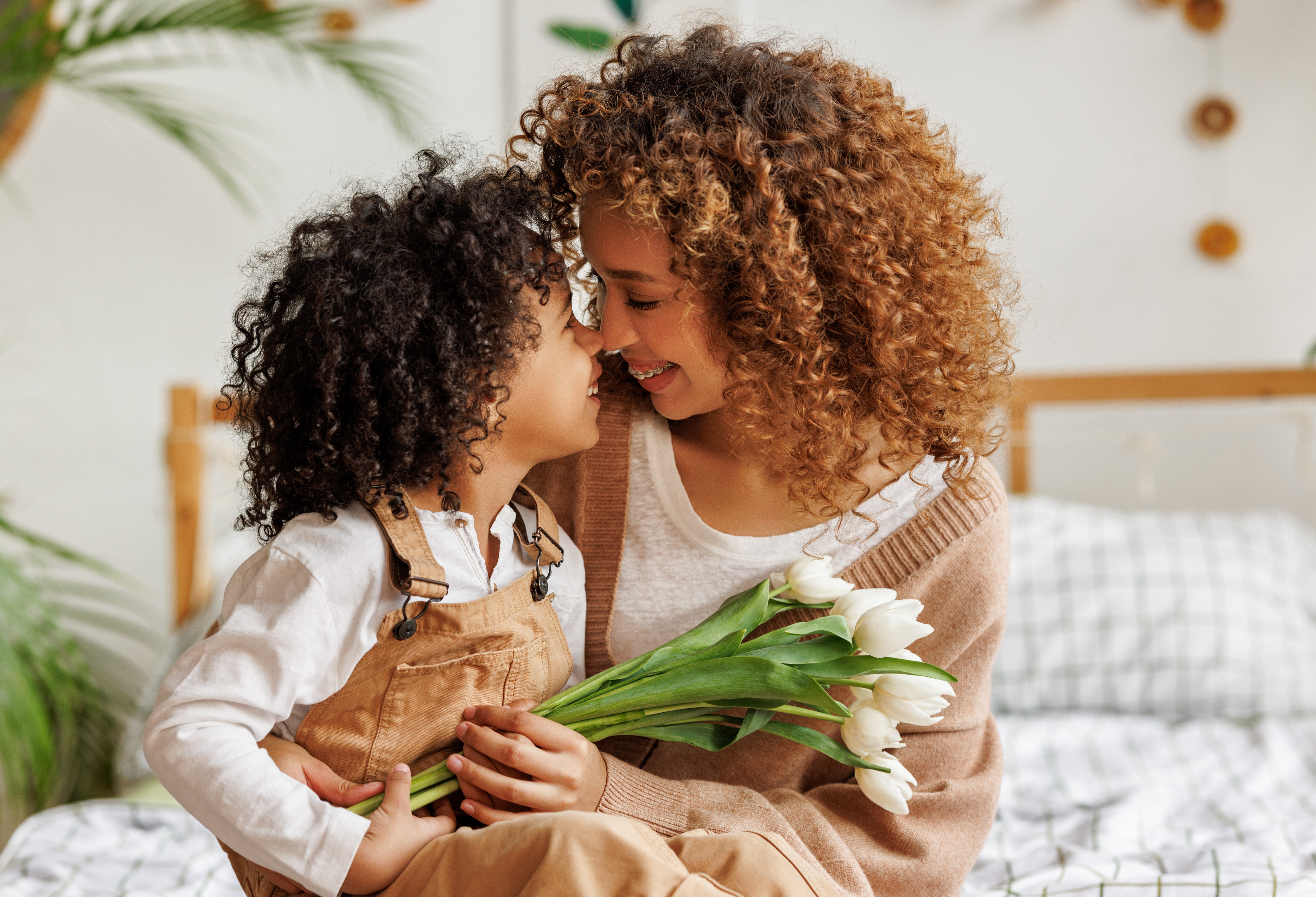mother receiving white tulips from her child