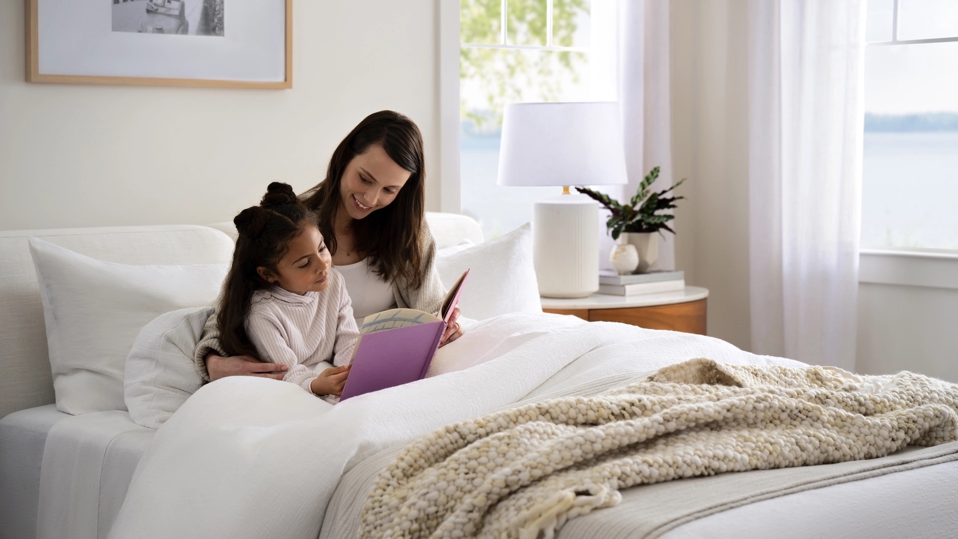 Two people sitting on bed reading
