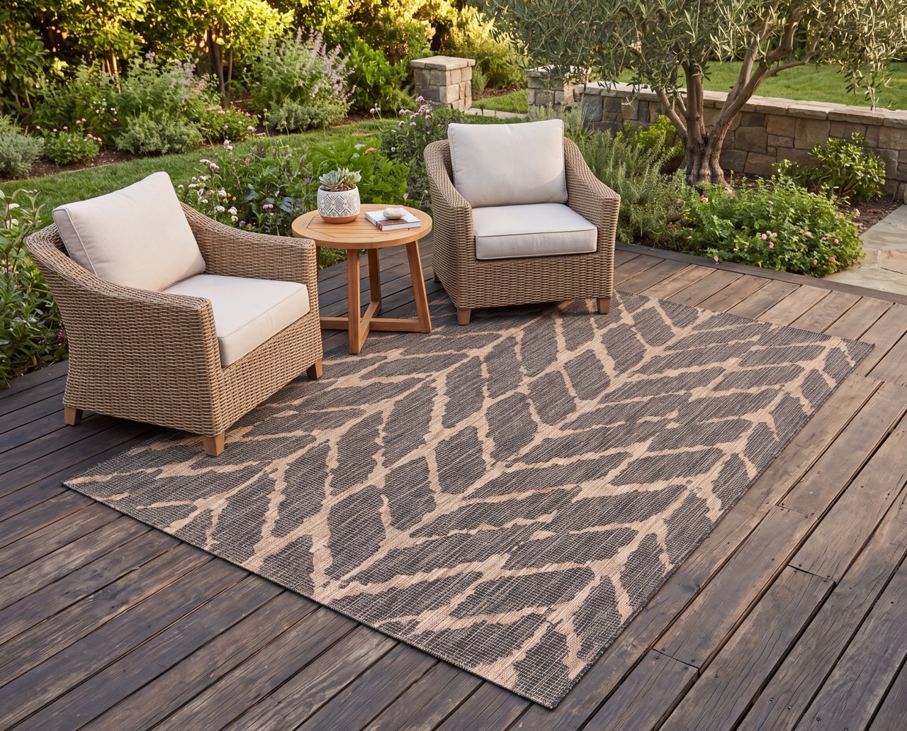 Brown and sand outdoor rug on a deck with two accent chairs and an end table