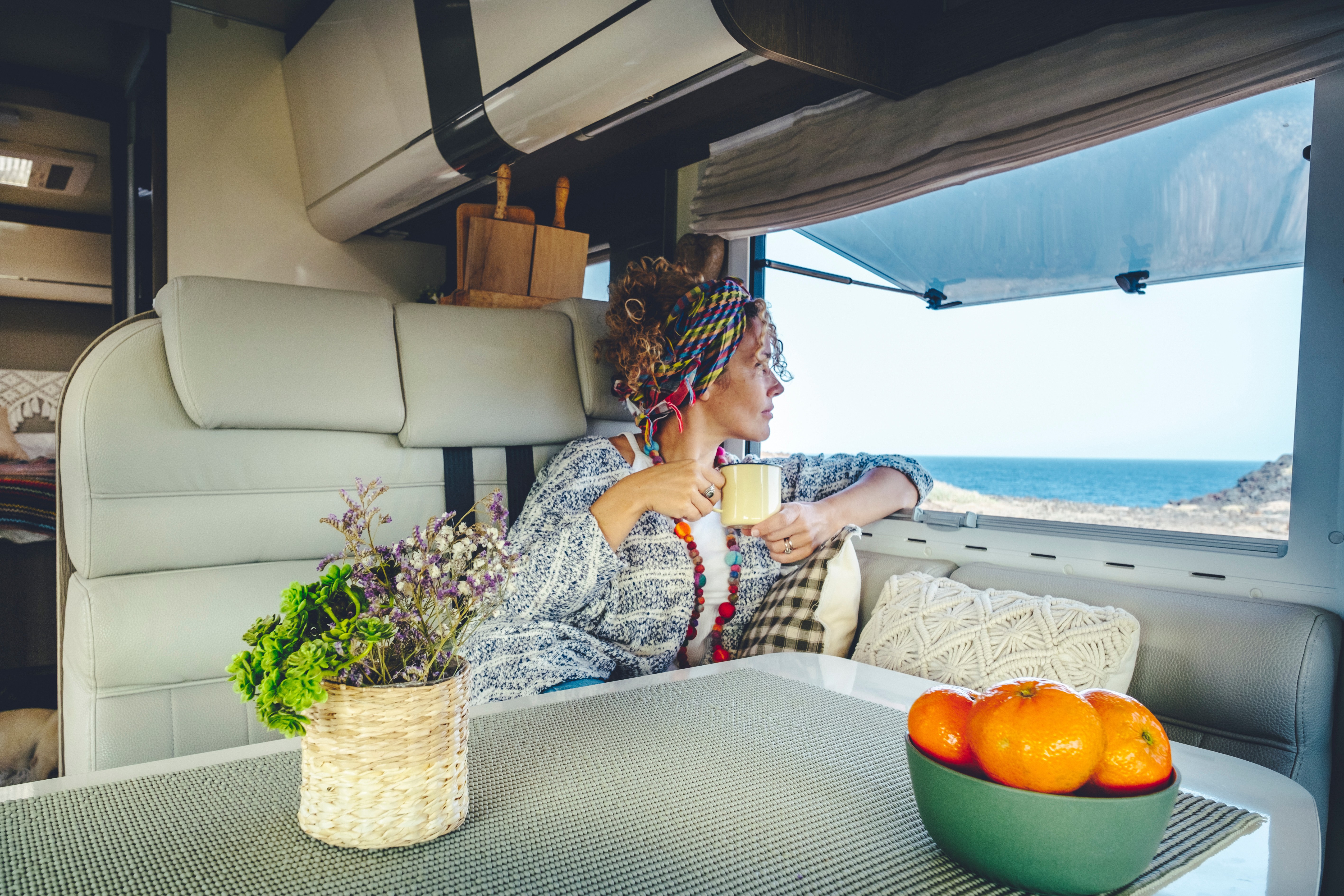 Woman at her van table enjoying an ocean view with coffee