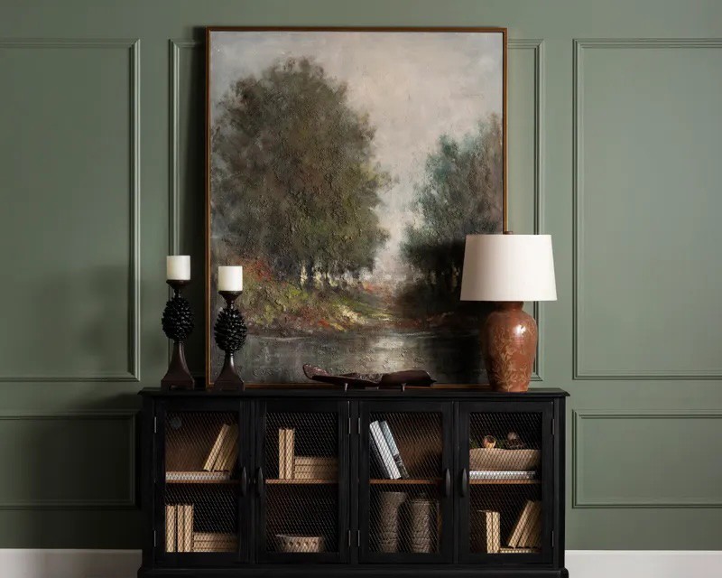Oil panting against sage green wall with molded wall framing