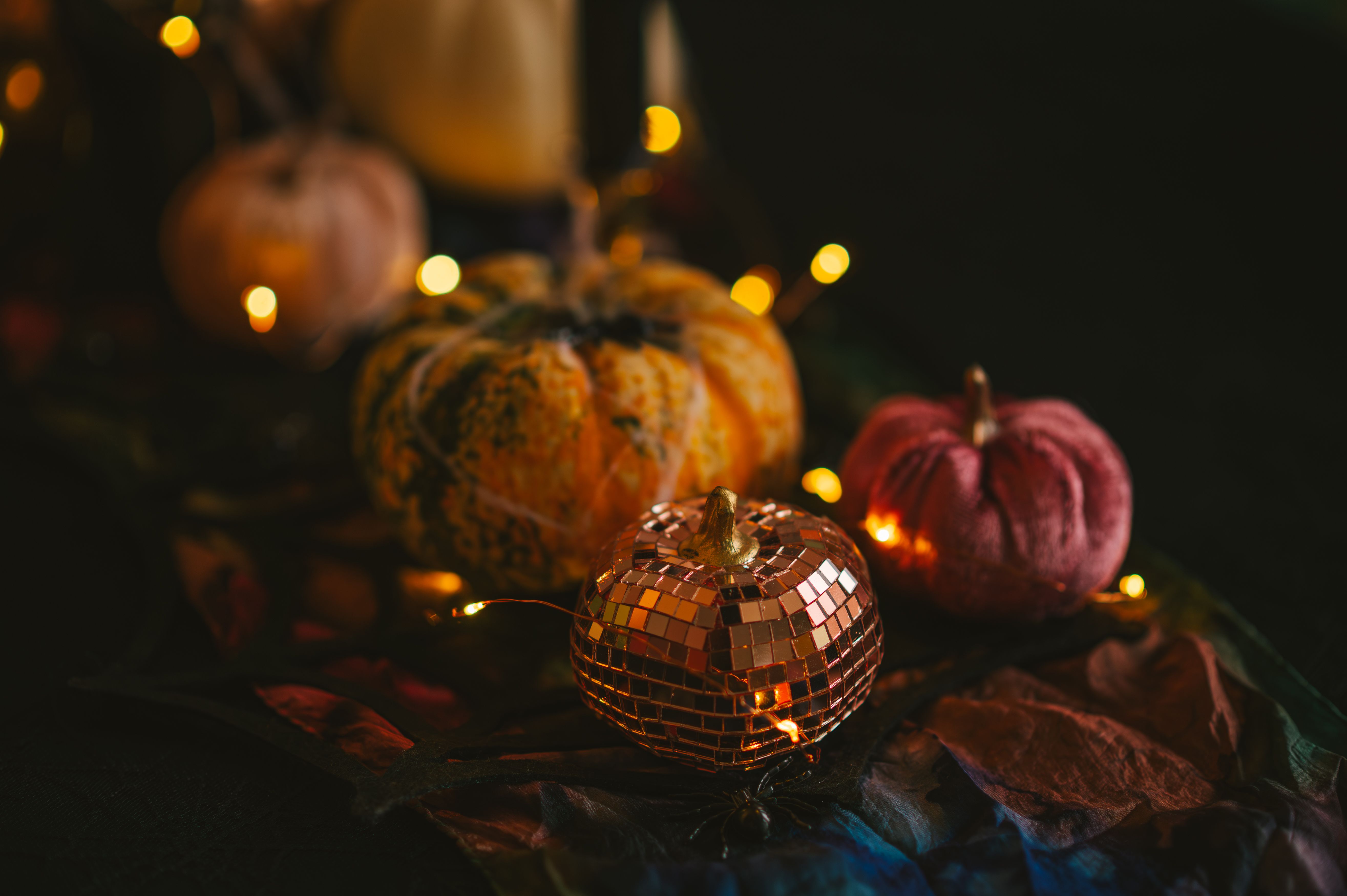 dark halloween setting with a variety of small pumpkins