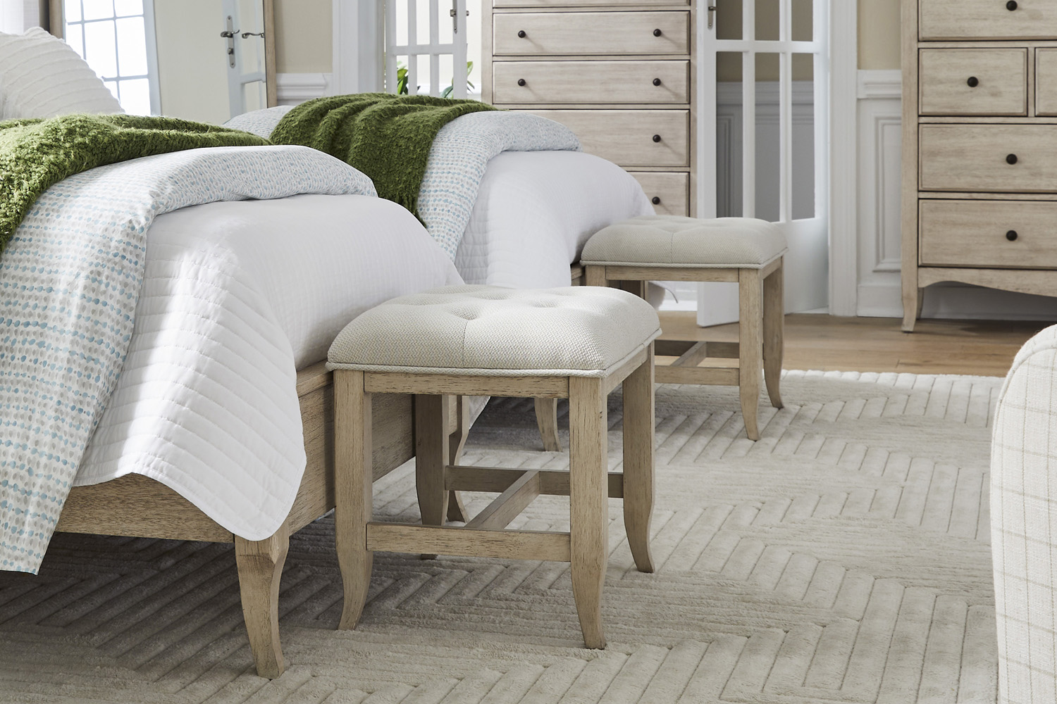 Two twin beds with a bench at the foot of each bed