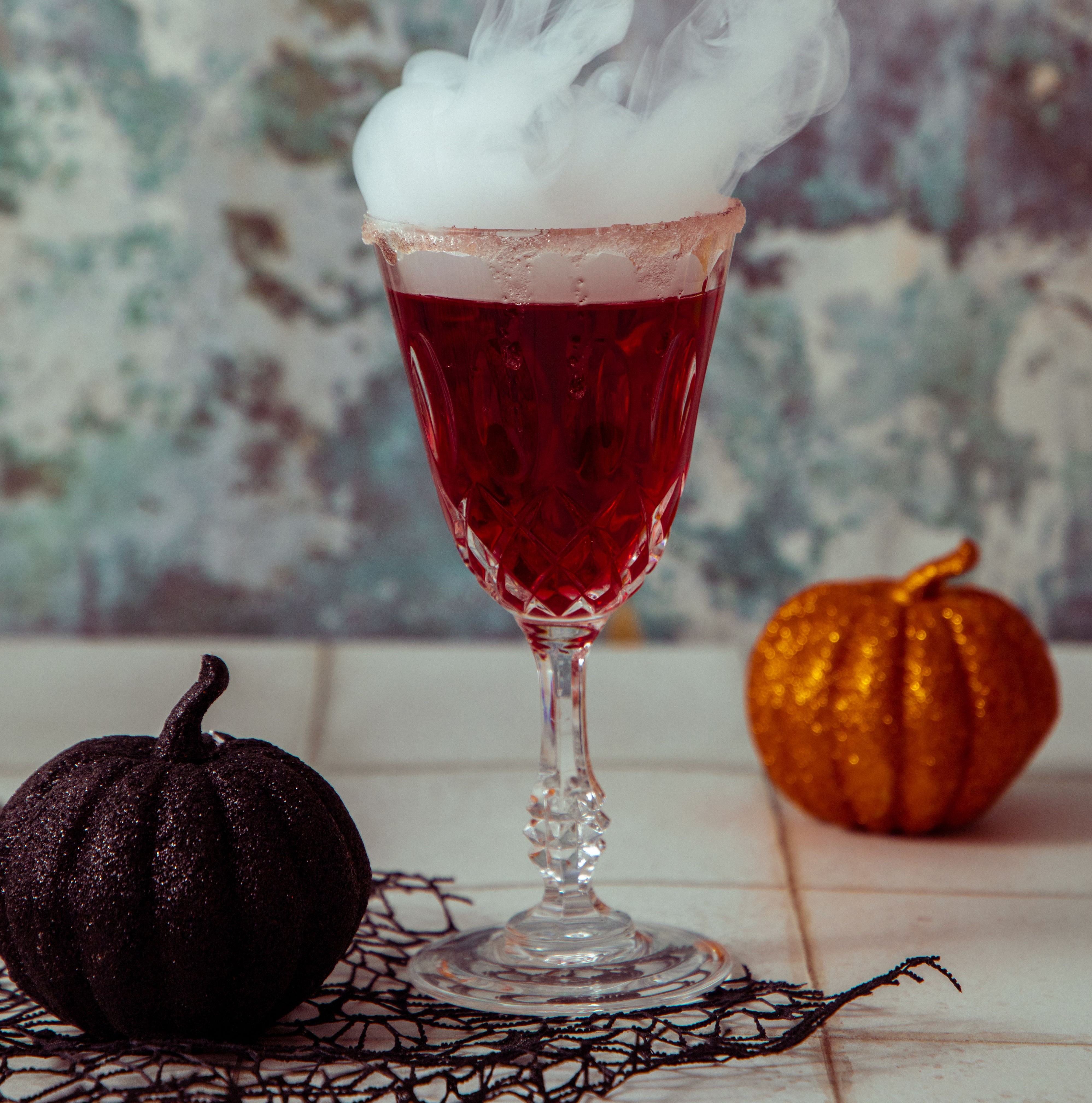 smoky drink in glass with flanked in halloween decor