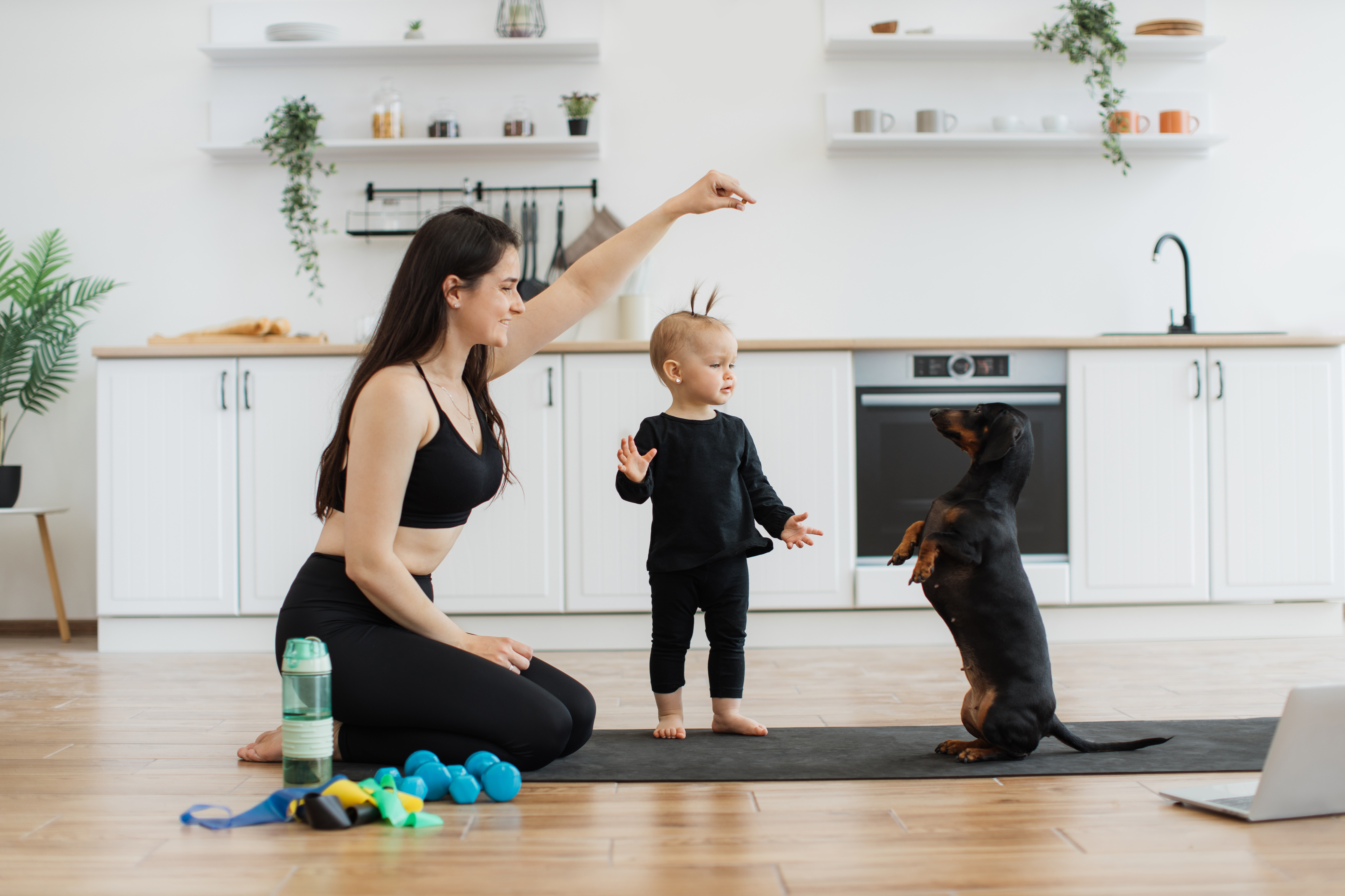 Mom in kitchen with toddler and small dog