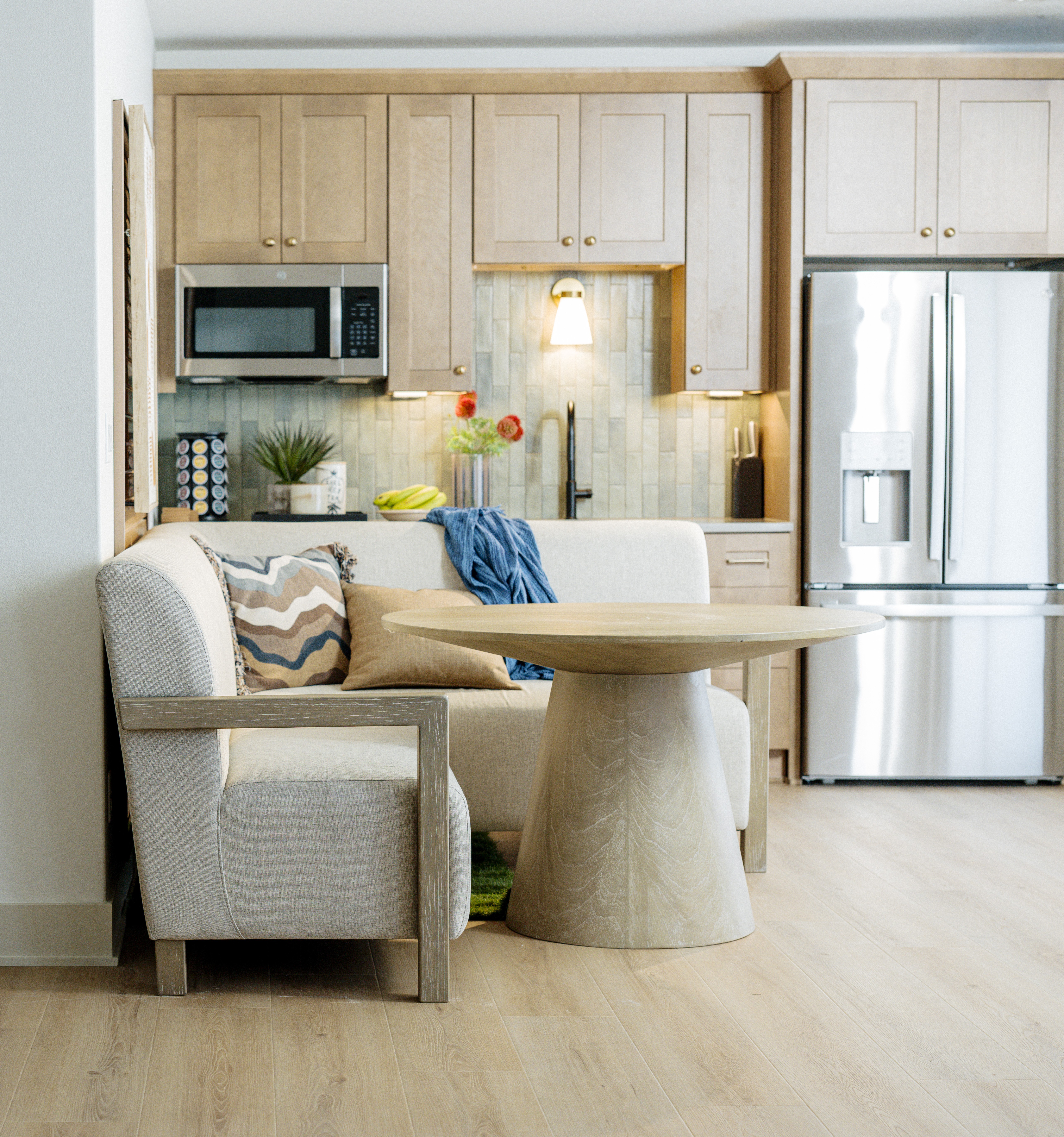 Curved-base dining table in light wood of casual kitchen