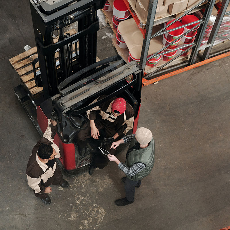 men around forklift in warehouse